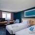 Travelodge London Kingston Upon Thames room with twin beds, desk, window and blue accent wall