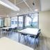 Residencia Universitaria Resa Los Abedules in Pamplona study room with tables, chairs, and large windows