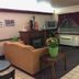 Jameson Inn Bowling Green lobby seating area with sofa, fireplace, TV, and window air conditioner