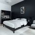Mint House at 70 Pine, New York bedroom with black accent wall, bed, armchair and potted tree
