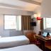 Ours Blanc Victor Hugo Toulouse guest room with twin beds, desk, wall mirror and red lamps