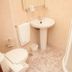 Hotel La Ronda in Castro-Urdiales bathroom with pedestal sink, toilet, and glass shower enclosure