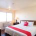 Budgetlodge Oklahoma City guest room with double bed, red runner, nightstands and window air conditioner