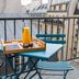 LYRIC Hotel Paris Opera balcony with table, chairs and city rooftop views in Paris