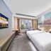 Zhongshan Tegao Business Hotel room with twin beds and city mural in Zhongshan