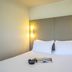 Campanile Mulhouse Sud - Morschwiller guest room with double bed and wall sconces in Mulhouse