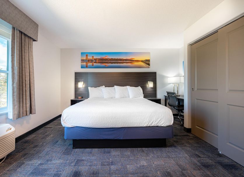 Independence Stay Hotel and Long term suites in Houghton guest room with king bed, large window and desk
