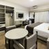 Plaza Blumenau Hotel room in Blumenau with bed, round table, desk, closet and wall-mounted TV