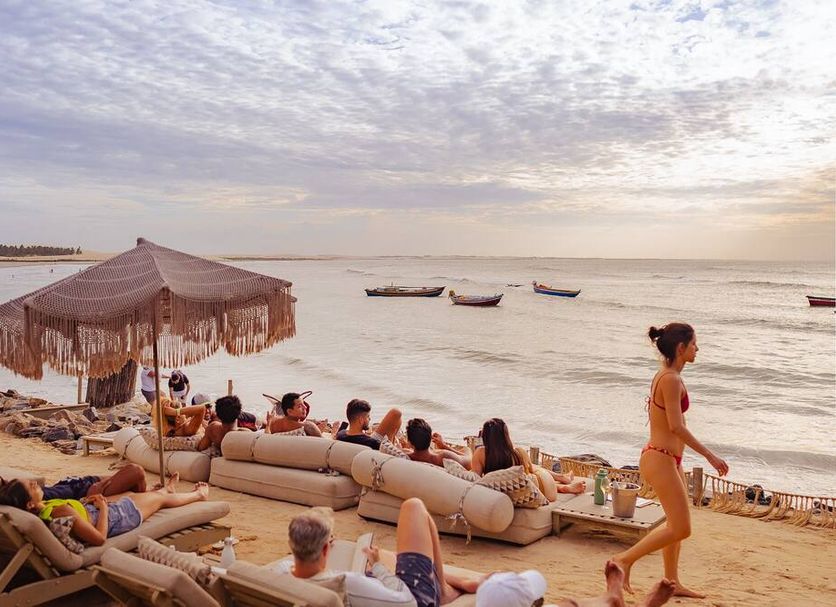 Casa Na Praia Jeri beachfront lounge with sofas, umbrella and ocean sunset in Jijoca de Jericoacoara
