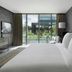 Four Seasons Hotel Bengaluru at Embassy One guest room with king bed and balcony pool view in Bengaluru