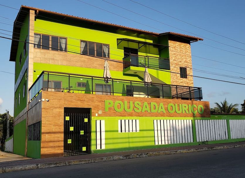 Pousada Ouriço in Porto de Galinhas exterior with bright green and wood facade and street view