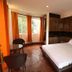 Sudha's Garden Home in Kathmandu: simple guest room with double bed, wooden floors, and orange curtains