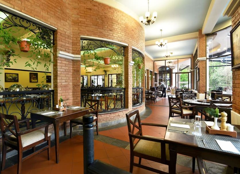 Park Village Resort By Kgh Group Kathmandu restaurant with arched windows and outdoor dining area