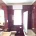 Residence Valbella in Bibione bathroom with burgundy tile, bathtub, sink, toilet and shower panel