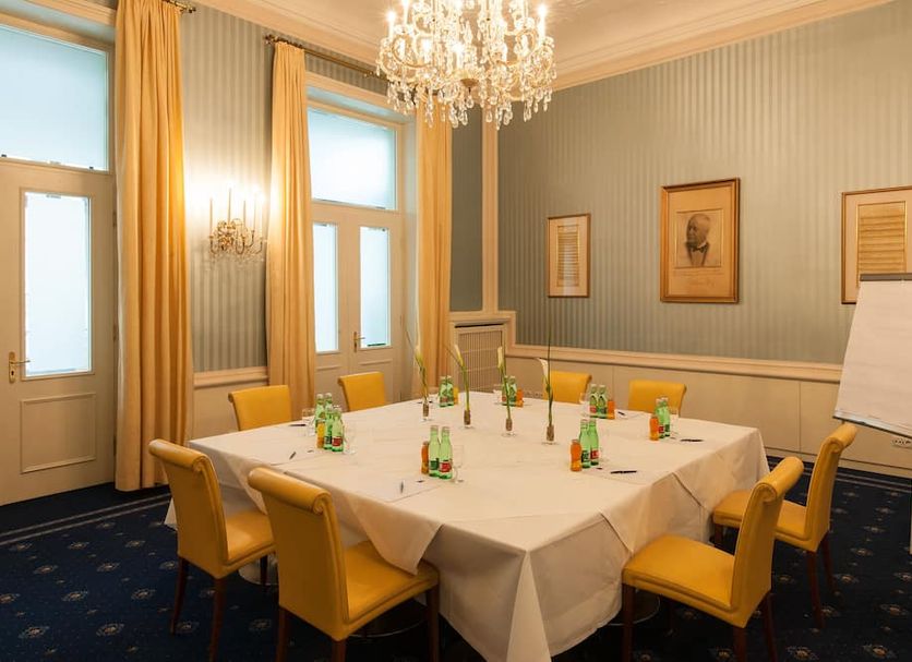 Ambassador Hotel Vienna meeting room with table set for conference under chandelier
