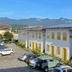 Pousada Fortaleza in Paraty with white buildings, yellow-trim windows, parking, and mountain views