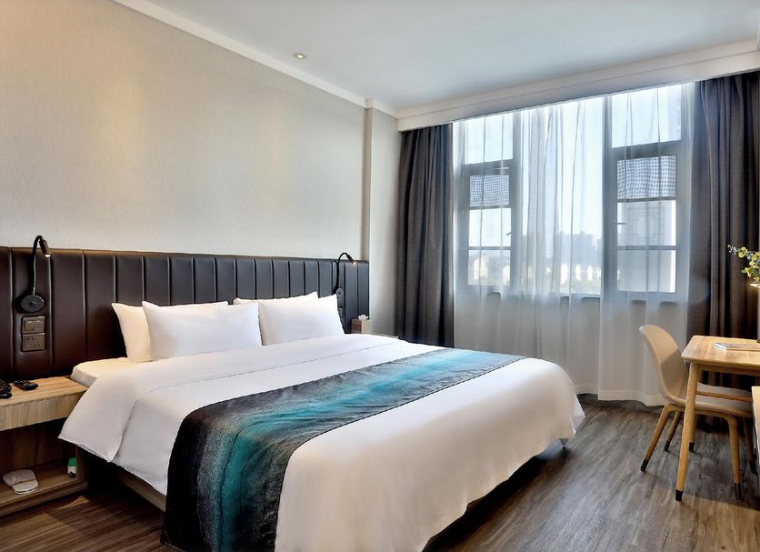Hanting Express Hangzhou Cuiyuan Branch guest room with king bed, desk, and large window in Hangzhou