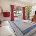 Bamboo Bungalow Resthouse Boracay room with bed, TV, and open doorway to a covered balcony in Boracay