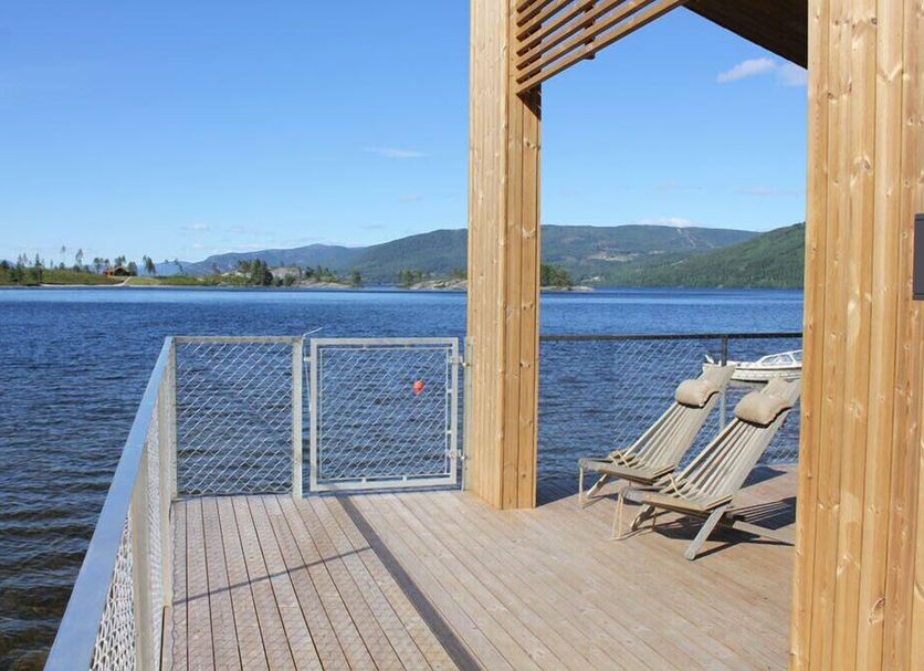 Nisser Hyttegrend Og Camping in Treungen: lakeside deck with lounge chairs and mountain views