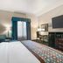 Best Western Sonora Inn & Suites in Nogales guest room with king bed, seating area, desk and wall-mounted TV