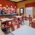 Breakfast area at Best Western Executive Inn El Campo with tables, chairs, and beverage dispensers