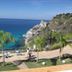 Blue Bay Resort in Capo Vaticano with panoramic sea view, poolside loungers, and rocky coastline