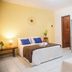 Pousada Velha Boipeba room with two beds, tiled floor, wooden door and open wardrobe in Velha Boipeba