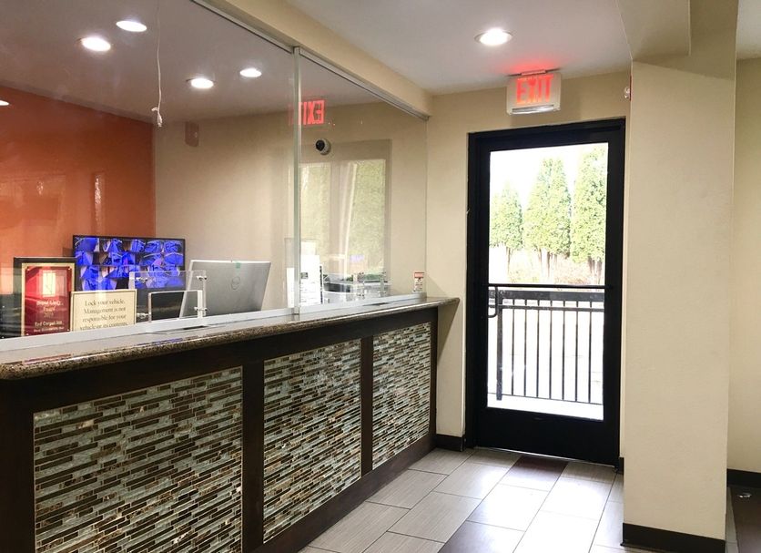 Red Carpet Inn - New Brunswick front desk with glass entry door and tiled lobby area