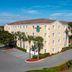 Homewood Suites by Hilton Bonita Springs Naples North exterior in Bonita Springs with palm trees and parking lot