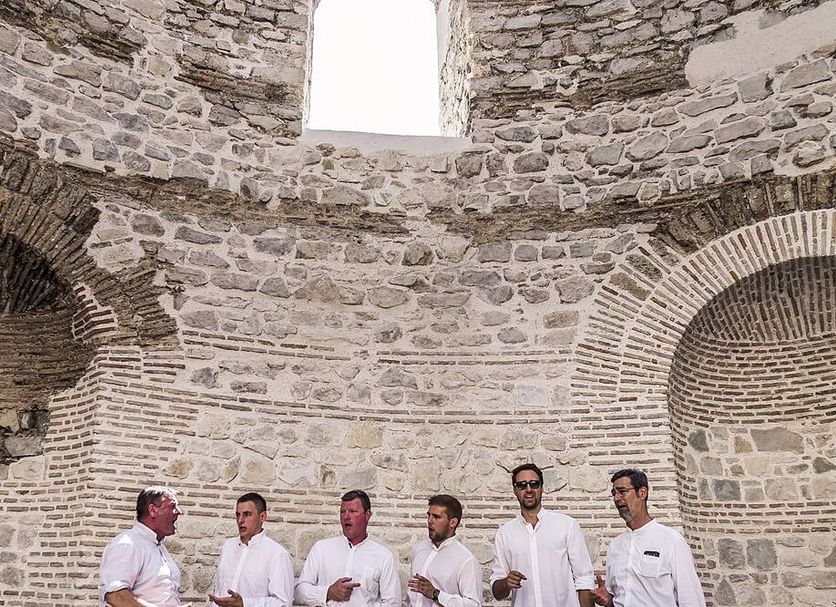 Bella Notte Di Spalato in Split, stone interior with five men standing beneath arched openings