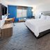 Holiday Inn Express & Suites Dumas by IHG guest room with king bed, window seat and TV in Dumas