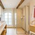 Tides Boutique Hotel in Norden bathroom with double sink, walk-in shower and arched window
