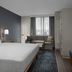 Homewood Suites by Hilton Portsmouth Downtown guest room with king bed, sitting area, and window view