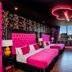 The Shankly Hotel Liverpool room with two pink beds, neon ceiling light and city view