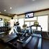 Coral Jubail Hotel in Al Jubail gym with treadmills, dumbbells, mirrors and wall-mounted TV
