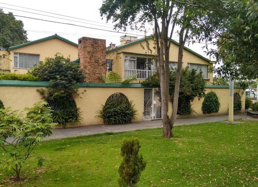 Hostal Bogotá Real in Bogotá, exterior view with landscaped lawn and trees