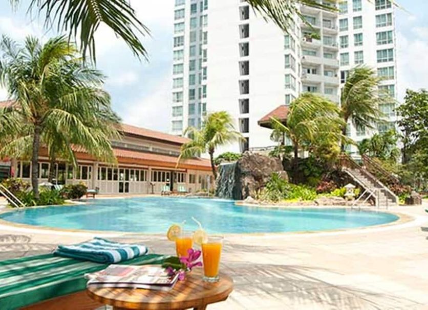 Poolside view at The Residences at Puri Casablanca in Jakarta with palm trees and high-rise towers