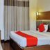 Hotel aroma classic Jaipur guest room with double bed, red accents, curtains, and wall lamp