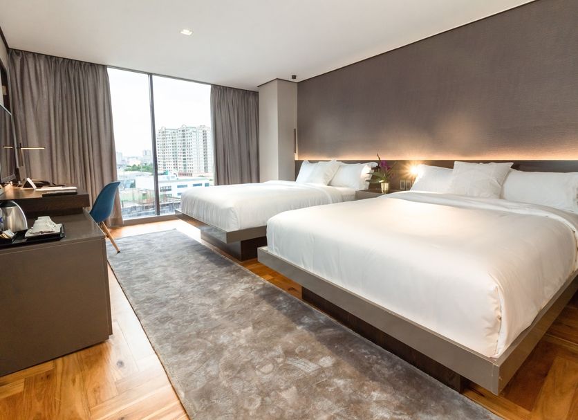 Ramada Encore by Wyndham Makati twin room with city-view window and floor-to-ceiling curtains