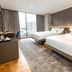 Ramada Encore by Wyndham Makati twin room with city-view window and floor-to-ceiling curtains