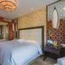 Beijing Rishengchang Hotel bedroom with king bed, glass-walled bathroom and geometric accent wall in Beijing