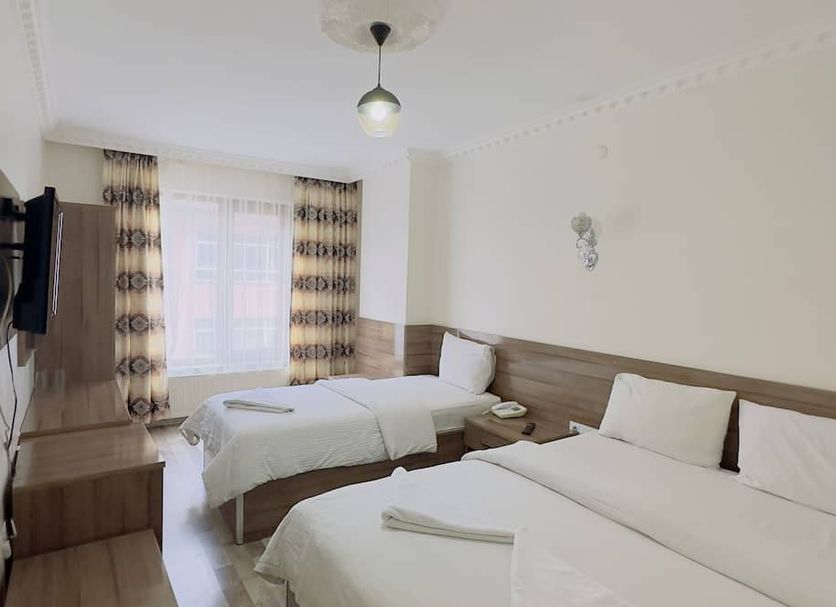 Toprak Hotel in Van guest room with two single beds, wall-mounted TV and window curtains