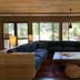 Station House Inn South Lake Tahoe lounge with sectional sofa, coffee table, and large windows to greenery.