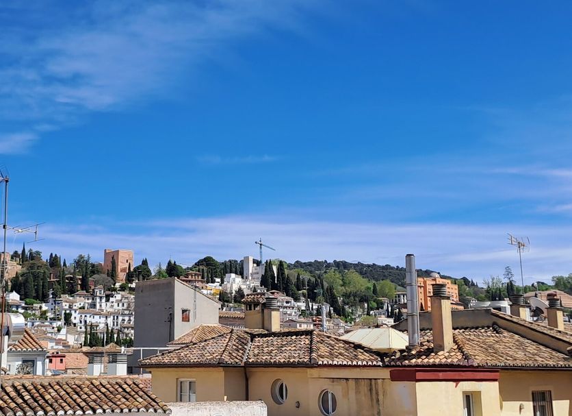 Nest Style Granada rooftop view over Granada skyline and church towers under a blue sky