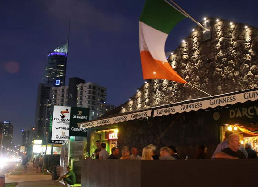 Darcy Arms Hotel Motel in Surfers Paradise, outdoor pub seating with Guinness signage and city skyline at night