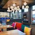 Aloft Waco Downtown lounge with colorful seating, hanging globe lights and a bar in Waco