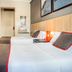 Ch Las Murallas in Madrid: simple twin room with three beds, bedside lamp, wall TV and bathroom door