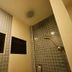 Bangrak Resort in Nakhon Sawan bathroom with tiled shower, wall-mounted TV, and rainfall showerhead.