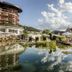 Hotel Bareiss in Baiersbronn with a reflective garden pond, poolside loungers, and mountain views