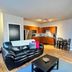 Cribs On The Hill in Picton: open-plan suite with black leather sofa, kitchenette and dining table